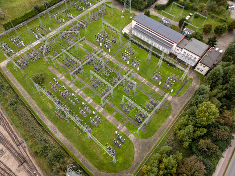 Aerial view of an electrical substation with high voltage equipment and metal structures set amidst green grass and trees in Gdansk Poland. Aerial view of an electrical substation with high voltage equipment and metal structures set amidst green grass and trees in Gdansk Poland.