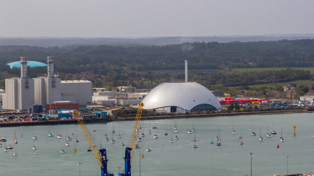 Aerial view of the Marchwood Power Station with its distinctive white dome industrial facilities and numerous sailboats moored in the harbor in Southampton England United Kingdom. Aerial view of the Marchwood Power Station with its distinctive white dome industrial facilities and numerous sailboats moored in the harbor in Southampton England United Kingdom.