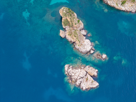 Aerial view of the rocky islets of Riserva Naturale Orientata dello Zingaro surrounded by clear blue sea in San Vito Lo Capo Sicilia Italy. Aerial view of the rocky islets of Riserva Naturale Orientata dello Zingaro surrounded by clear blue sea in San Vito Lo Capo Sicilia Italy.