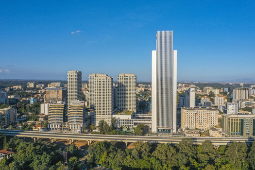 Aerial view of the Westlands district skyline featuring a prominent modern skyscraper surrounded by office buildings a highway and lush green trees in Nairobi Nairobi County Kenya. Aerial view of the Westlands district skyline featuring a prominent modern skyscraper surrounded by office buildings a highway and lush green trees in Nairobi Nairobi County Kenya.