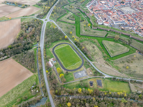 Aerial view of the star shaped fortifications surrounding the historic town contrasting with the modern road and sports field Neuf Brisach Grand Est France.