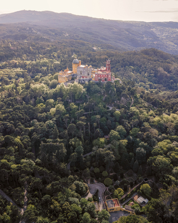 Aerial view of Pena Palace a colourful Romanticist castle building on hilltop during a beautiful sunset Sintra Lisbon Portugal.