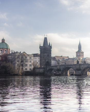 View of Charles Bridge and the Old Town Bridge Tower across the Vltava river with historic architecture under a bright sky Prague Prague Czechia. View of Charles Bridge and the Old Town Bridge Tower across the Vltava river with historic architecture under a bright sky Prague Prague Czechia.