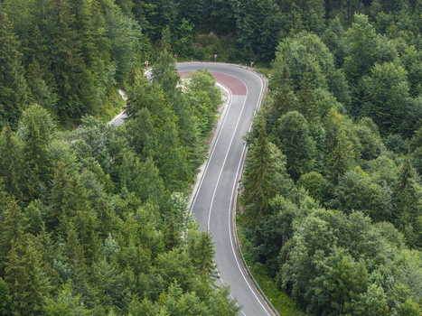 Aerial view of the winding Vernarske Chvalabohu mountain road surrounded by dense pine forests in Vernar Presovsky kraj Slovakia. Aerial view of the winding Vernarske Chvalabohu mountain road surrounded by dense pine forests in Vernar Presovsky kraj Slovakia.