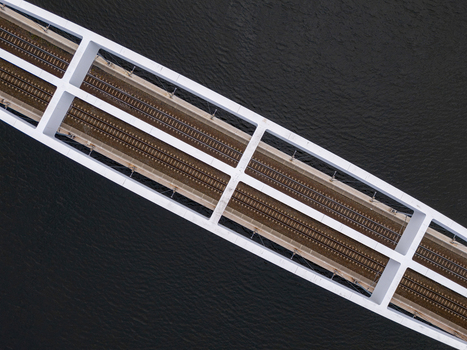 Aerial view of a modern white railway bridge spanning over dark water in Gdansk Poland. Aerial view of a modern white railway bridge spanning over dark water in Gdansk Poland.