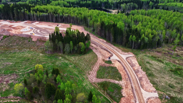 Aerial view of a wind turbine maintenance road winding through a forest and cleared land in Latvija. Aerial view of a wind turbine maintenance road winding through a forest and cleared land in Latvija.