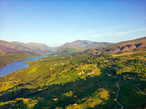 Aerial view of the scenic landscape near Cwm y glo featuring the blue waters of Llyn Padarn rolling green hills and rugged mountainous terrain in Cwm y glo Wales United Kingdom. Aerial view of the scenic landscape near Cwm y glo featuring the blue waters of Llyn Padarn rolling green hills and rugged mountainous terrain in Cwm y glo Wales United Kingdom.