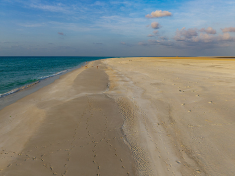 Aerial view of turquoise waves kissing the golden sands of Qalanciya lagoon under a serene sky Qalanciya Socotra Yemen.