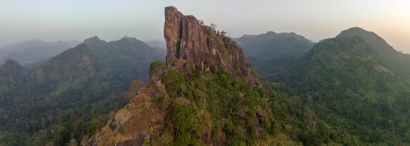 Aerial view of the iconic La Dent de Man rocky peak rising above lush green hills and dense tropical forests in Man Montagnes District Cote d Ivoire.