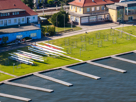 Aerial view of the Berlin Grunau Regatta Course with rowing boats stored on the grass wooden docks extending into the water and surrounding buildings in Berlin Berlin Germany. Aerial view of the Berlin Grunau Regatta Course with rowing boats stored on the grass wooden docks extending into the water and surrounding buildings in Berlin Berlin Germany.
