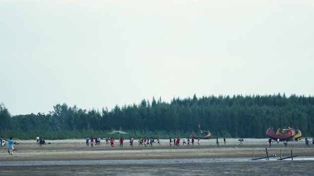 View of people playing football on the beach Bangladesh.