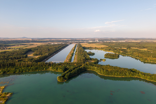 Aerial view of Labe Arena Racice rowing canal surrounded by lush forests and calm water under a clear sky in Racice Ustecky kraj Czechia. Aerial view of Labe Arena Racice rowing canal surrounded by lush forests and calm water under a clear sky in Racice Ustecky kraj Czechia.