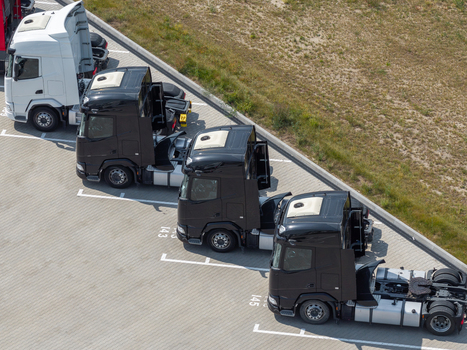 Aerial view of several semi trucks parked in a paved lot in Warsaw Masovian Voivodeship Poland. Aerial view of several semi trucks parked in a paved lot in Warsaw Masovian Voivodeship Poland.