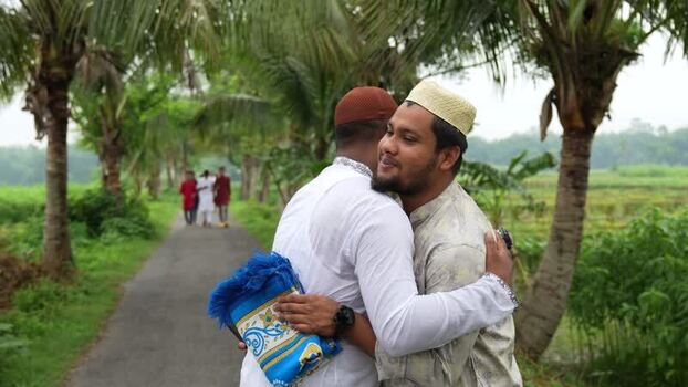 View of two Muslim men hugging on a rural road Bangladesh. View of two Muslim men hugging on a rural road Bangladesh.