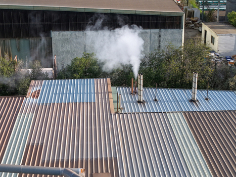 Melbourne Australia 22 September 2026 Aerial view of industrial factory rooftops with metal corrugated sheets and smoking chimneys in an urban area. Melbourne Australia 22 September 2026 Aerial view of industrial factory rooftops with metal corrugated sheets and smoking chimneys in an urban area.