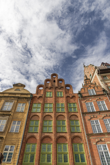 Gdansk Poland 07 September 2026 View of historic brick buildings with ornate stepped gables and green framed windows under a cloudy blue sky. Gdansk Poland 07 September 2026 View of historic brick buildings with ornate stepped gables and green framed windows under a cloudy blue sky.