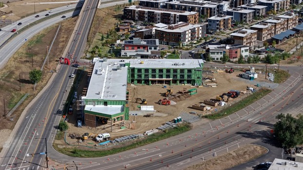 Aerial view of a construction site with a partially built building heavy machinery and surrounding roads in Boulder Colorado United States. Aerial view of a construction site with a partially built building heavy machinery and surrounding roads in Boulder Colorado United States.