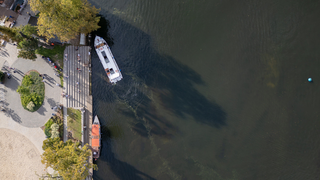 Aerial view of the vibrant Brda River reflecting the sky as boats glide past the stepped embankment near the lush greenery Bydgoszcz Województwo kujawsko pomorskie Poland. Aerial view of the vibrant Brda River reflecting the sky as boats glide past the stepped embankment near the lush greenery Bydgoszcz Województwo kujawsko pomorskie Poland.