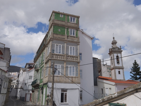 View of a traditional building with green tiled facade and white balconies situated in the historic streets of Covilha Castelo Branco District Portugal.