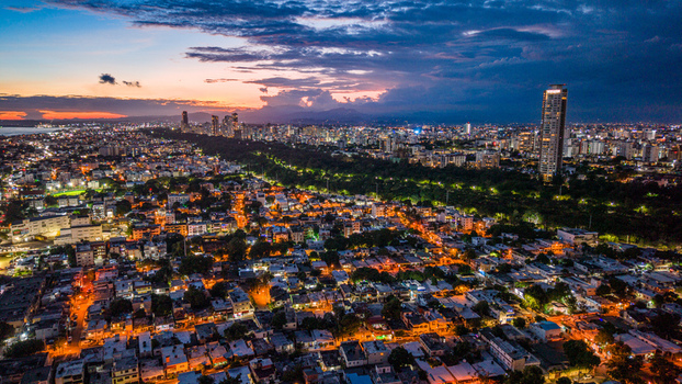 Aerial view of the Santo Domingo skyline at twilight featuring the illuminated Caney Tower rising above the dense urban landscape in Santo Domingo Distrito Nacional Dominican Republic. Aerial view of the Santo Domingo skyline at twilight featuring the illuminated Caney Tower rising above the dense urban landscape in Santo Domingo Distrito Nacional Dominican Republic.
