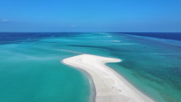 Aerial view of a white sandbar in the turquoise sea Maldives.