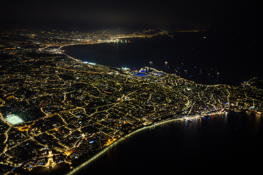 Aerial view of the illuminated coastline and city lights of Antibes at night along the French Riviera in Antibes Provence Alpes Cote d Azur France. Aerial view of the illuminated coastline and city lights of Antibes at night along the French Riviera in Antibes Provence Alpes Cote d Azur France.