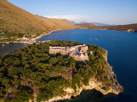 Aerial view of the historic Porto Palermo Castle on a green peninsula surrounded by the blue waters of the Ionian Sea Porto Palermo Qarku i Vlores Albania. Aerial view of the historic Porto Palermo Castle on a green peninsula surrounded by the blue waters of the Ionian Sea Porto Palermo Qarku i Vlores Albania.
