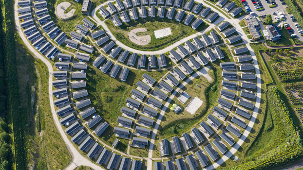 Aerial view of a modern holiday park with rows of small houses arranged in a circular pattern surrounded by green lawns and pathways in Venlo Limburg Netherlands. Aerial view of a modern holiday park with rows of small houses arranged in a circular pattern surrounded by green lawns and pathways in Venlo Limburg Netherlands.