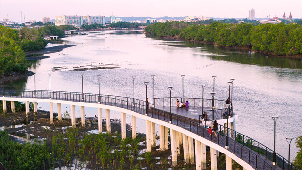 Iloilo City Western Visayas Philippines 18 July 2026 Aerial view of Iloilo Sunset Boulevard with people on the boardwalk surrounded by mangroves and the river under a soft evening sky.