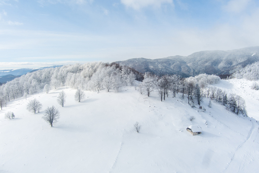 Brasov Romania 21 September 2026 Aerial view of a snow covered landscape in the Carpathian Mountains featuring a small wooden cabin nestled among frost covered trees. Brasov Romania 21 September 2026 Aerial view of a snow covered landscape in the Carpathian Mountains featuring a small wooden cabin nestled among frost covered trees.