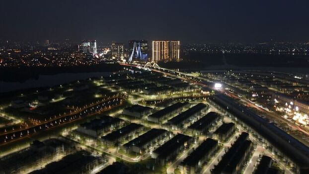 Aerial view of the illuminated Golf Island and Orchestra bridge at night featuring modern residential blocks and glowing city lights in Kecamatan Penjaringan Daerah Khusus Ibukota Indonesia. Aerial view of the illuminated Golf Island and Orchestra bridge at night featuring modern residential blocks and glowing city lights in Kecamatan Penjaringan Daerah Khusus Ibukota Indonesia.