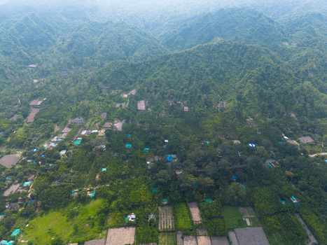 Aerial view of lush green hills and dense tropical vegetation with small settlements and agricultural fields in Cox s Bazar Chittagong Division Bangladesh. Aerial view of lush green hills and dense tropical vegetation with small settlements and agricultural fields in Cox s Bazar Chittagong Division Bangladesh.