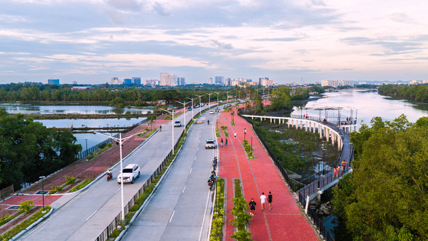 Iloilo City Philippines 18 July 2026 Aerial view of Iloilo Sunset Boulevard with its red paved walkway adjacent road lush mangroves and the city skyline under a soft evening sky.