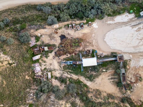 Aerial view of a waste processing facility with sorting machinery industrial containers and piles of organic material in the rural landscape of Teulada Valencian Community Spain.