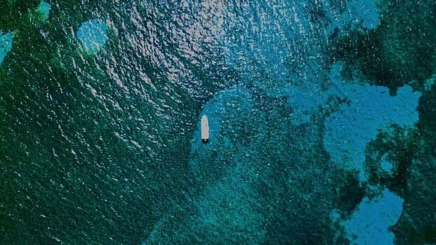 Aerial view of a boat on turquoise water in Guanaja Honduras. Aerial view of a boat on turquoise water in Guanaja Honduras.