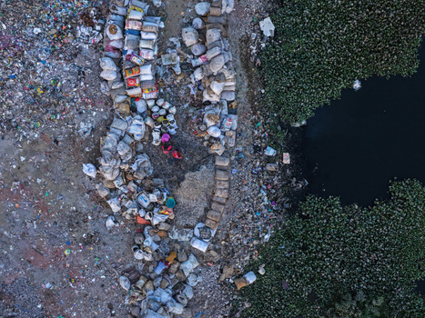 Aerial view of Buriganga River bank with piles of waste sacks and people working in Dhaka Dhaka Division Bangladesh. Aerial view of Buriganga River bank with piles of waste sacks and people working in Dhaka Dhaka Division Bangladesh.