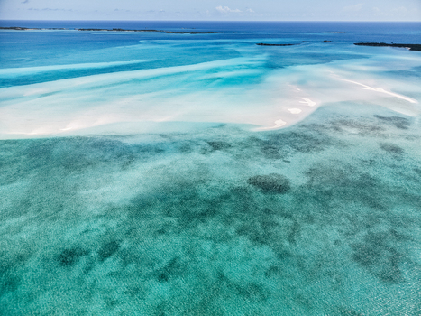 Aerial view of Man O War Cay Sandbar with turquoise waters and coral reefs under a clear blue sky in Rolletown Exuma The Bahamas. Aerial view of Man O War Cay Sandbar with turquoise waters and coral reefs under a clear blue sky in Rolletown Exuma The Bahamas.