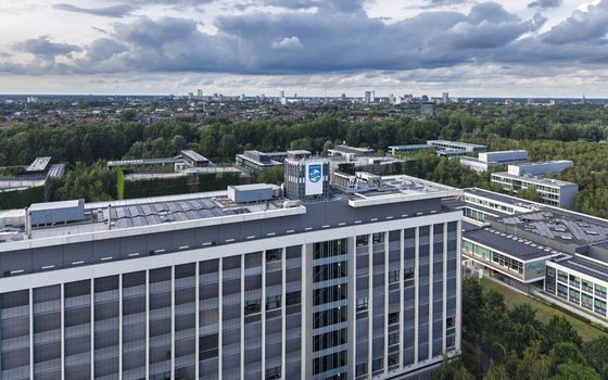 Aerial view of High Tech Campus Eindhoven featuring modern office buildings surrounded by lush greenery under a cloudy sky in Eindhoven Noord Brabant Netherlands. Aerial view of High Tech Campus Eindhoven featuring modern office buildings surrounded by lush greenery under a cloudy sky in Eindhoven Noord Brabant Netherlands.