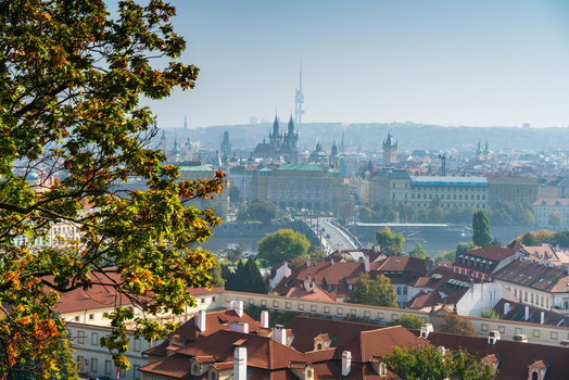 View of the historic Prague skyline with red tiled rooftops the Vltava river and the Zizkov Television Tower in the distance under a clear sky Prague Prague Czechia.
