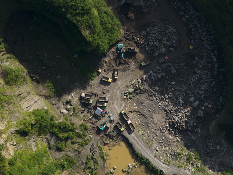 Aerial view of Tambang Pasir Merapi Kali Gendol Sand Mine with excavators and dump trucks operating on rocky terrain Kecamatan Cangkringan Daerah Istimewa Yogya Indonesia. Aerial view of Tambang Pasir Merapi Kali Gendol Sand Mine with excavators and dump trucks operating on rocky terrain Kecamatan Cangkringan Daerah Istimewa Yogya Indonesia.