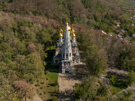 Aerial view of Shipka Memorial Church with its golden domes surrounded by dense autumn forest in the mountains of Shipka Stara Zagora Bulgaria. Aerial view of Shipka Memorial Church with its golden domes surrounded by dense autumn forest in the mountains of Shipka Stara Zagora Bulgaria.
