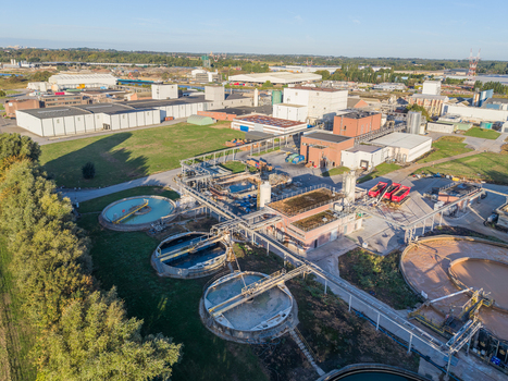 Aerial view of the wastewater treatment plant featuring circular sedimentation tanks industrial buildings and pipes in Vilvoorde Flanders Belgium. Aerial view of the wastewater treatment plant featuring circular sedimentation tanks industrial buildings and pipes in Vilvoorde Flanders Belgium.