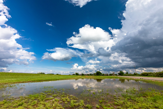 View of a flooded field reflecting dramatic storm clouds in the sky in Oklahoma City Oklahoma United States.