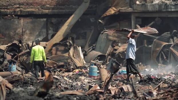 View of people walking through fire ruins in Dhaka Bangladesh. View of people walking through fire ruins in Dhaka Bangladesh.