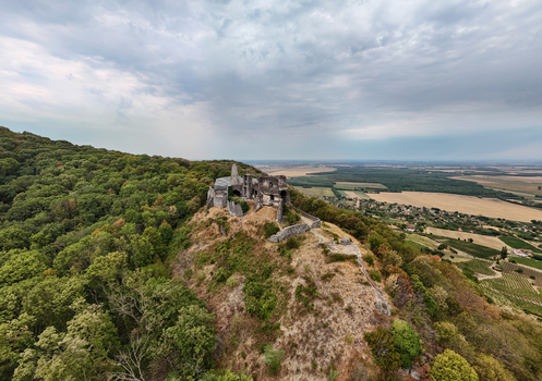 Aerial view of Somlo Castle ruins above vineyards and forest in rural Hungarian countryside Aerial view of Somlo Castle ruins above vineyards and forest in rural Hungarian countryside