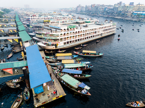 Aerial view of Sadarghat river port with numerous passenger ferries and small boats docked along the Buriganga River in Dhaka Dhaka Division Bangladesh. Aerial view of Sadarghat river port with numerous passenger ferries and small boats docked along the Buriganga River in Dhaka Dhaka Division Bangladesh.