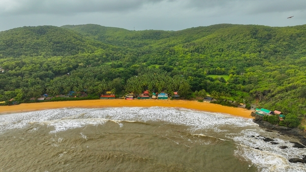 Aerial view of Om Beach Birdview Point with golden sands lush green hills and waves crashing on the shore in Gokarna Karnataka India. Aerial view of Om Beach Birdview Point with golden sands lush green hills and waves crashing on the shore in Gokarna Karnataka India.