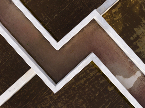 Aerial view of a zigzag concrete structure at a wastewater treatment facility in Diepenbeek Flanders Belgium. Aerial view of a zigzag concrete structure at a wastewater treatment facility in Diepenbeek Flanders Belgium.