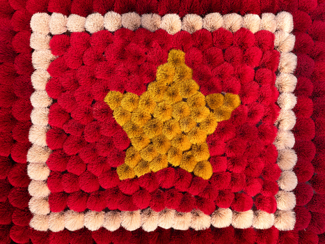 Aerial view of a textured flag of Vietnam crafted from red and yellow pom poms creating a soft tactile surface in Vietnam. Aerial view of a textured flag of Vietnam crafted from red and yellow pom poms creating a soft tactile surface in Vietnam.