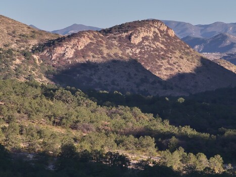Aerial view of the rugged Sierra de San Miguelito mountains with dense pine forests rocky slopes and deep shadows cast across the landscape San Luis Potosi San Luis Potosi Mexico. Aerial view of the rugged Sierra de San Miguelito mountains with dense pine forests rocky slopes and deep shadows cast across the landscape San Luis Potosi San Luis Potosi Mexico.